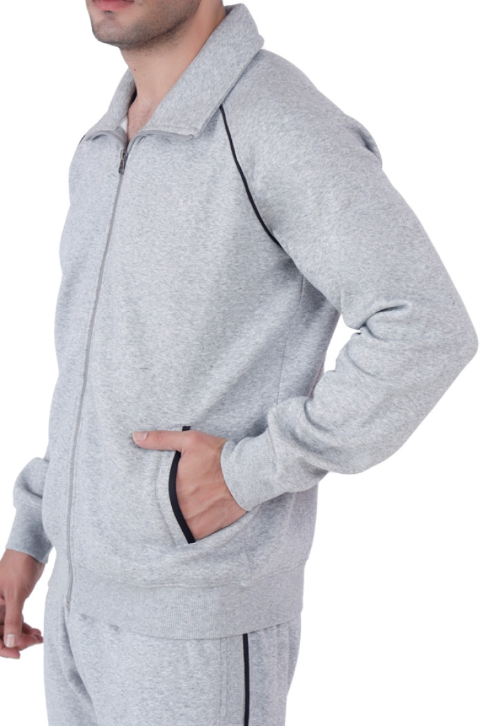 Close-up side view of a man wearing Trufit’s Grey Grindle zip-up tracksuit with a wide collar and black piping, with one hand placed in the pocket, highlighting fabric texture and seam details.